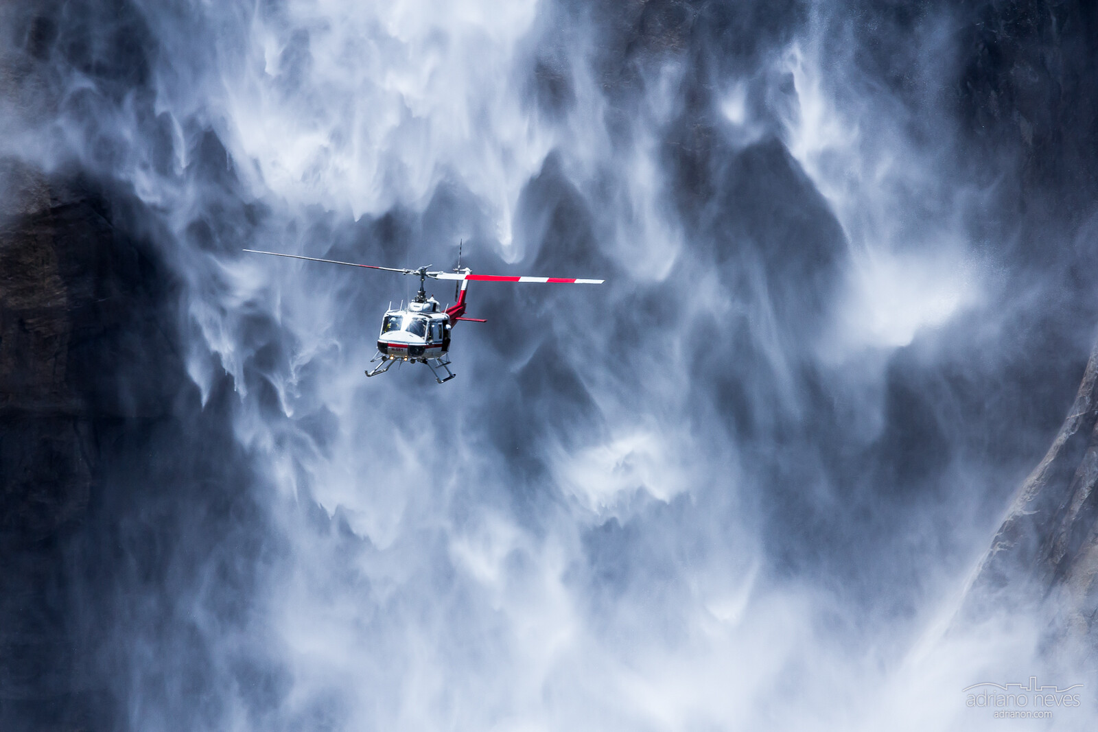 Dramatic freeze motion photograph of an helicopter in front of a giant waterfall - Adriano Neves - @acseven - adrianon.com